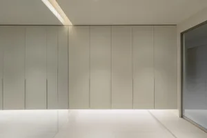 Modern minimalist metal closet system with white cabinets and sleek, minimalist design.