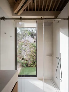 Modern minimalist bathroom with large glass window and concrete walls