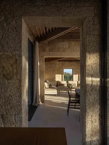 A minimalist living room with stone walls and a stone table.