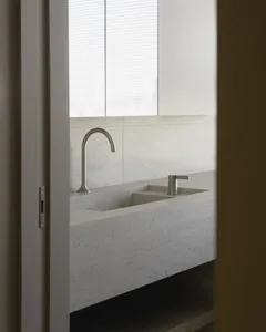 A modern bathroom with a sink made of concrete and a minimalist faucet design.