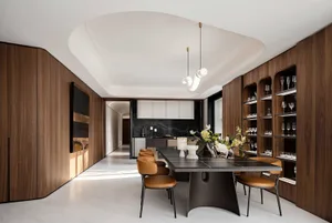 A modern dining room with wooden walls, leather chairs, and metal table base.