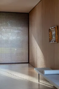 Modern interior with glass wall and geometric light patterns.