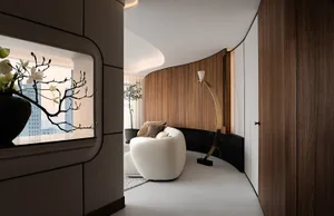 A modern living room featuring a curved wall, white sofa, and floor lamp.