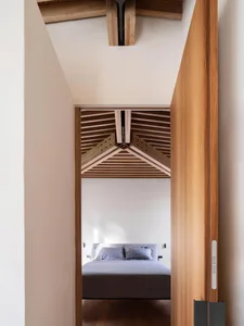 Modern minimalist bedroom featuring wooden beams and a simple design.