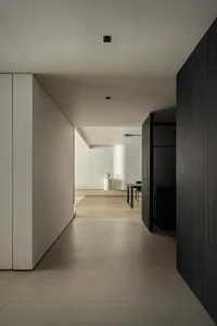 A minimalist modern hallway with concrete floors, wooden walls, and metal railings.