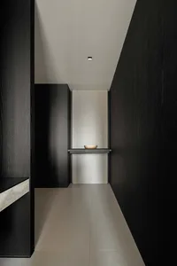 A minimalist room with dark wooden walls and a grey floor
