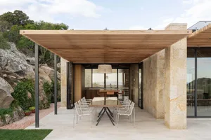 A modern patio featuring a wooden roof structure and outdoor dining area.