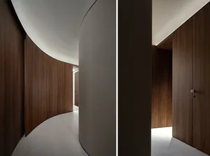 Modern interior corridor with curved wooden walls and white flooring.