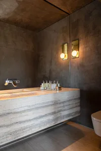 A minimalist bathroom with concrete walls and a modern sink。