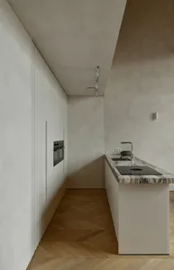 Modern minimalist kitchen featuring a marble countertop and floor-to-ceiling cabinets.