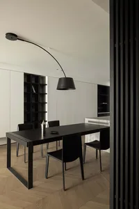 Modern dining room featuring a black dining table and matching chairs, complemented by a black floor lamp.