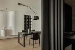 A modern living space featuring black tables and chairs with black stripes on a wooden floor.