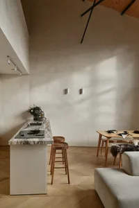 現代簡約廚房，配備大理石檯面與木質吧台椅。