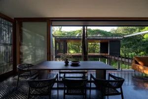 現代住宅餐廳區，搭配木質餐桌、餐椅、玻璃窗及鋼製框架