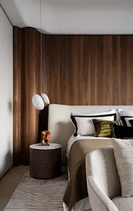 Minimalist bedroom with wood-paneled walls, marble bedside table, and fabric and leather upholstered furniture.