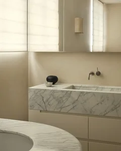 Modern minimalist bathroom featuring a white marble countertop with integrated sink and a neutral color palette.