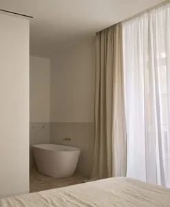 Minimalist bedroom featuring concrete flooring and furniture, creating a modern and sleek ambiance.
