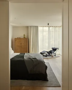Minimalist bedroom featuring wood furniture and fabric accents.