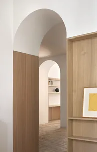 A minimalist interior space featuring wooden materials and architectural archways.
