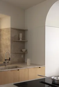Modern minimalist residential kitchen featuring wooden cabinets and marble countertops.