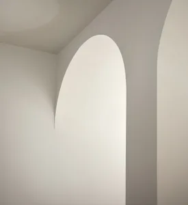 Minimalist white interior with arched doorways and walls.