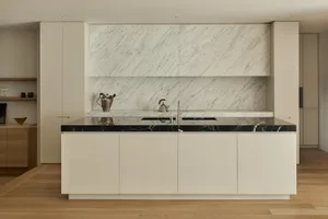 Modern kitchen with marble countertops and backsplash in a residential setting.