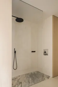 Modern minimalist bathroom featuring marble, glass, and concrete elements