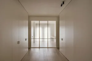 A minimalist bedroom with a glass door