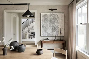 Minimalist living and dining room featuring wooden furniture and ceramic elements.