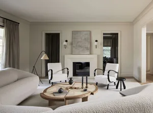 Modern living room featuring neutral-toned furniture and materials, minimalist design, and a cozy ambiance.