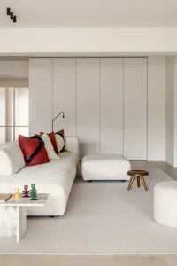 Modern living room with neutral-toned textiles, minimalist design, and sleek furniture.