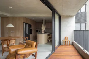 A modern residential kitchen featuring wood and concrete materials.