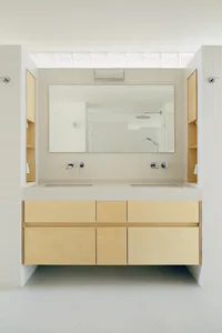 Modern industrial bathroom featuring a floating vanity with wooden cabinets and concrete countertops