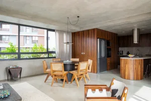 Modern apartment interior with open-plan living, dining, and kitchen areas in a minimalist design approach.