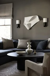 Minimalist living room featuring a textured fabric couch, modern coffee table with decorative vases, and abstract wall art.