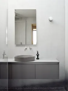 Modern bathroom with concrete sink, mirror, and cabinet.
