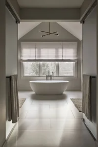 Modern bathroom with a white oval-shaped bathtub, floor-to-ceiling windows, and gray tile flooring.