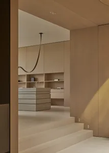 Modern minimalist kitchen featuring concrete countertops, wooden cabinetry, and metal finishes.