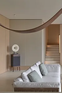 A modern minimalist living room with neutral-toned furniture and neutral-colored walls.