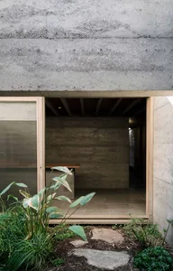Modern interior room with concrete walls and a wooden floor.