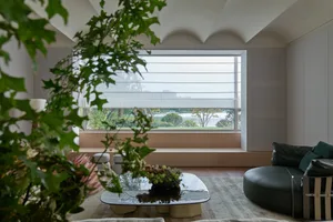 A modern living room with glass window overlooking greenery.