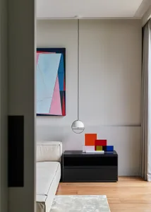 Modern living room with minimalist decor and a geometric abstract painting.