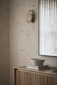 A modern minimalist bedroom featuring a wooden sideboard with a matte surface.
