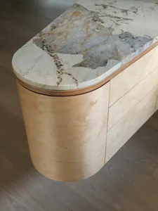 Modern minimalist kitchen featuring marble countertop and wooden cabinets.