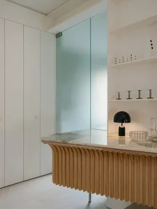 Modern kitchen featuring a marble counter top and wooden accents.