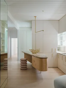 A modern minimalist kitchen featuring marble countertops and wooden elements