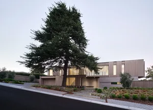A modern residential building with a wooden exterior and large glass windows.