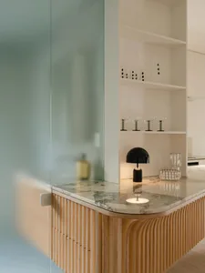 A minimalist interior with a wooden counter featuring a marble countertop.