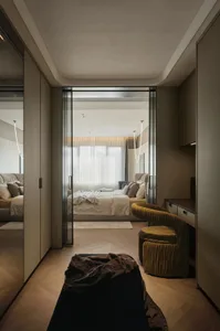 A modern minimalist bedroom with wooden flooring, upholstered furniture, and glass windows.