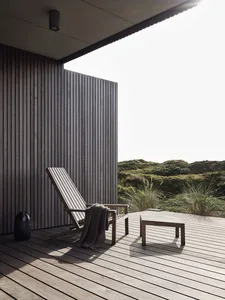 A minimalist outdoor lounge area featuring modern wooden furniture and a relaxing atmosphere.